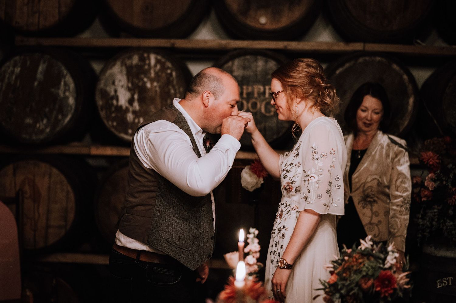 Intimate emotional exchange between couple in vintage wine cellar setting.