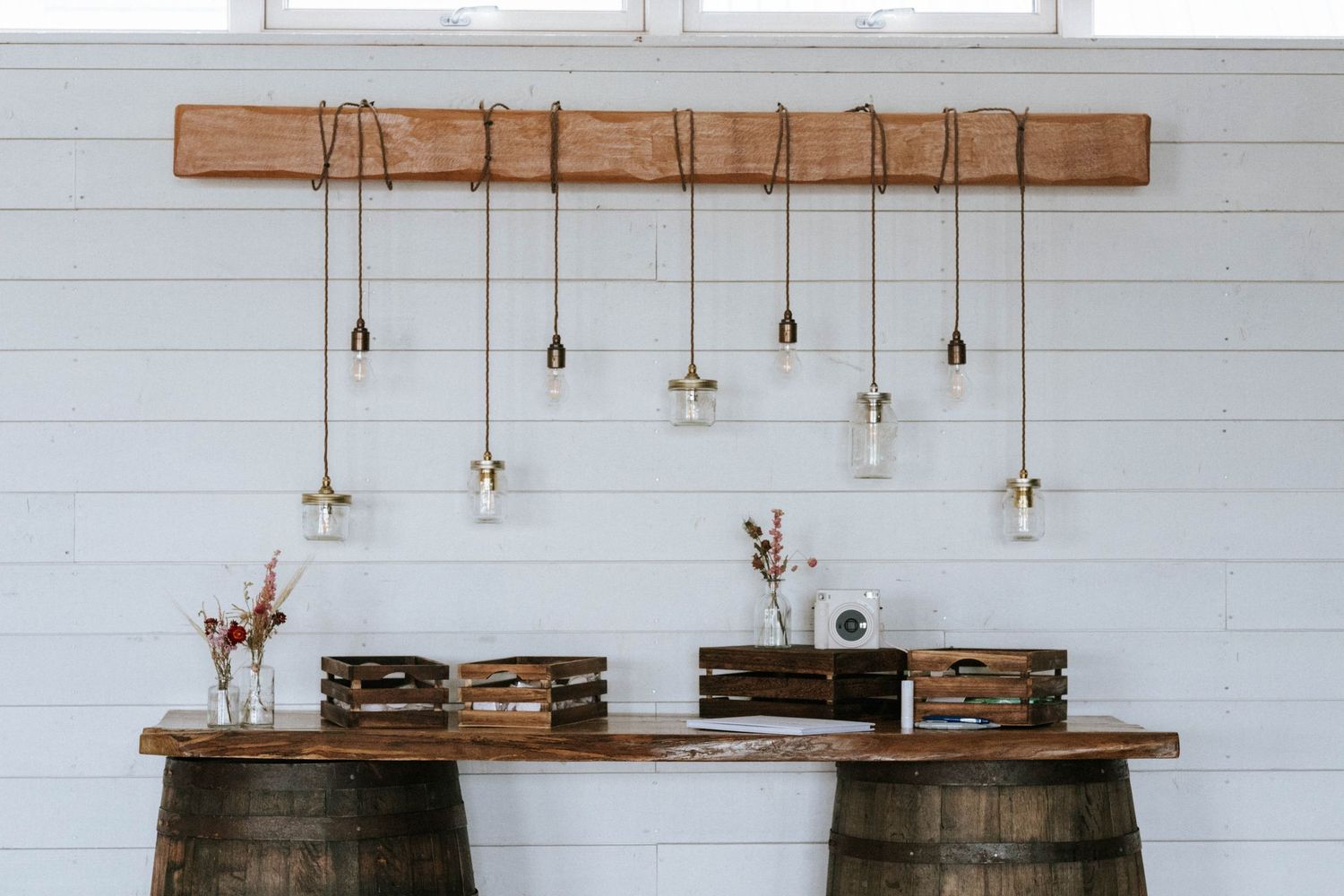 Modern farmhouse interior with shiplap walls, rustic wood beams, and pendant lighting over a dining area.