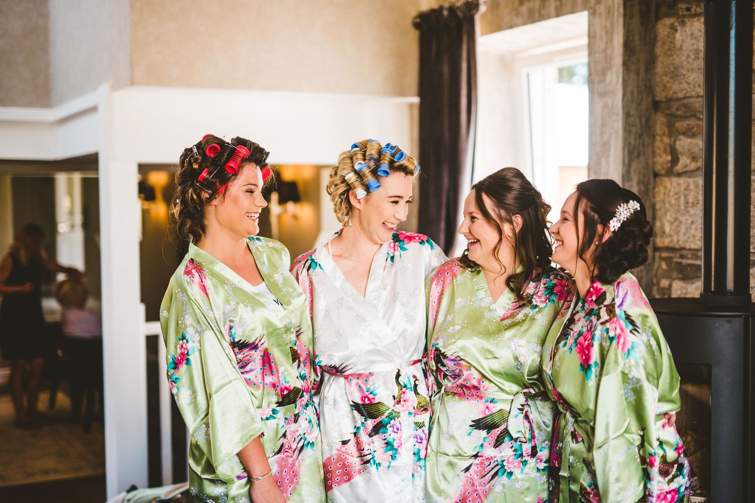 Bridesmaids in floral robes prepare for a wedding celebration.