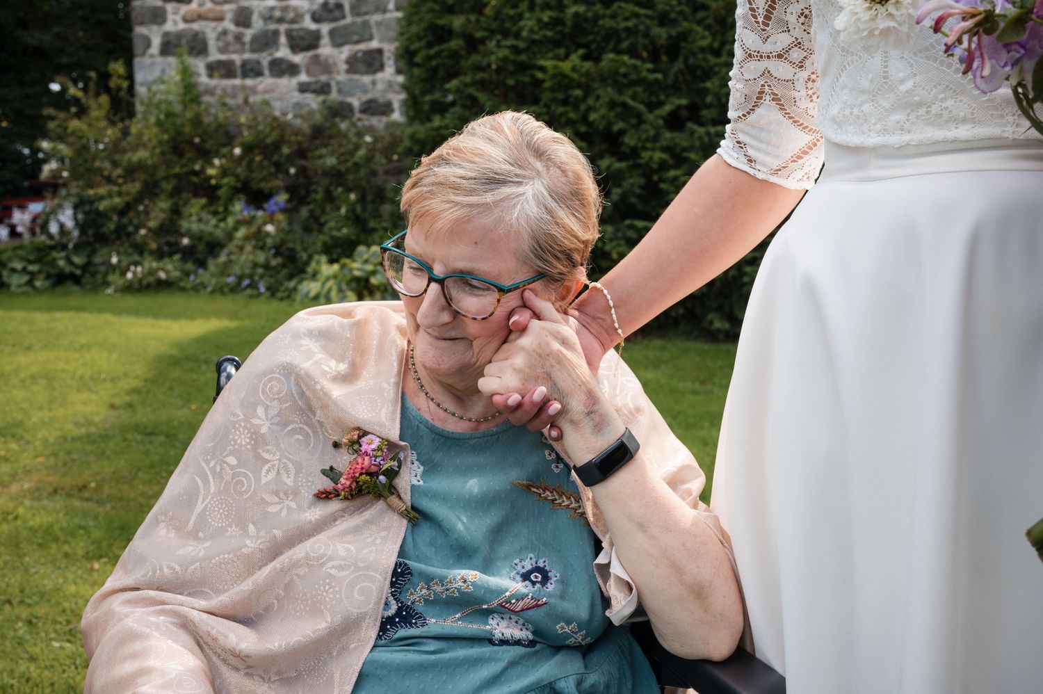 Wedding guests sharing an emotional moment in an outdoor garden setting.