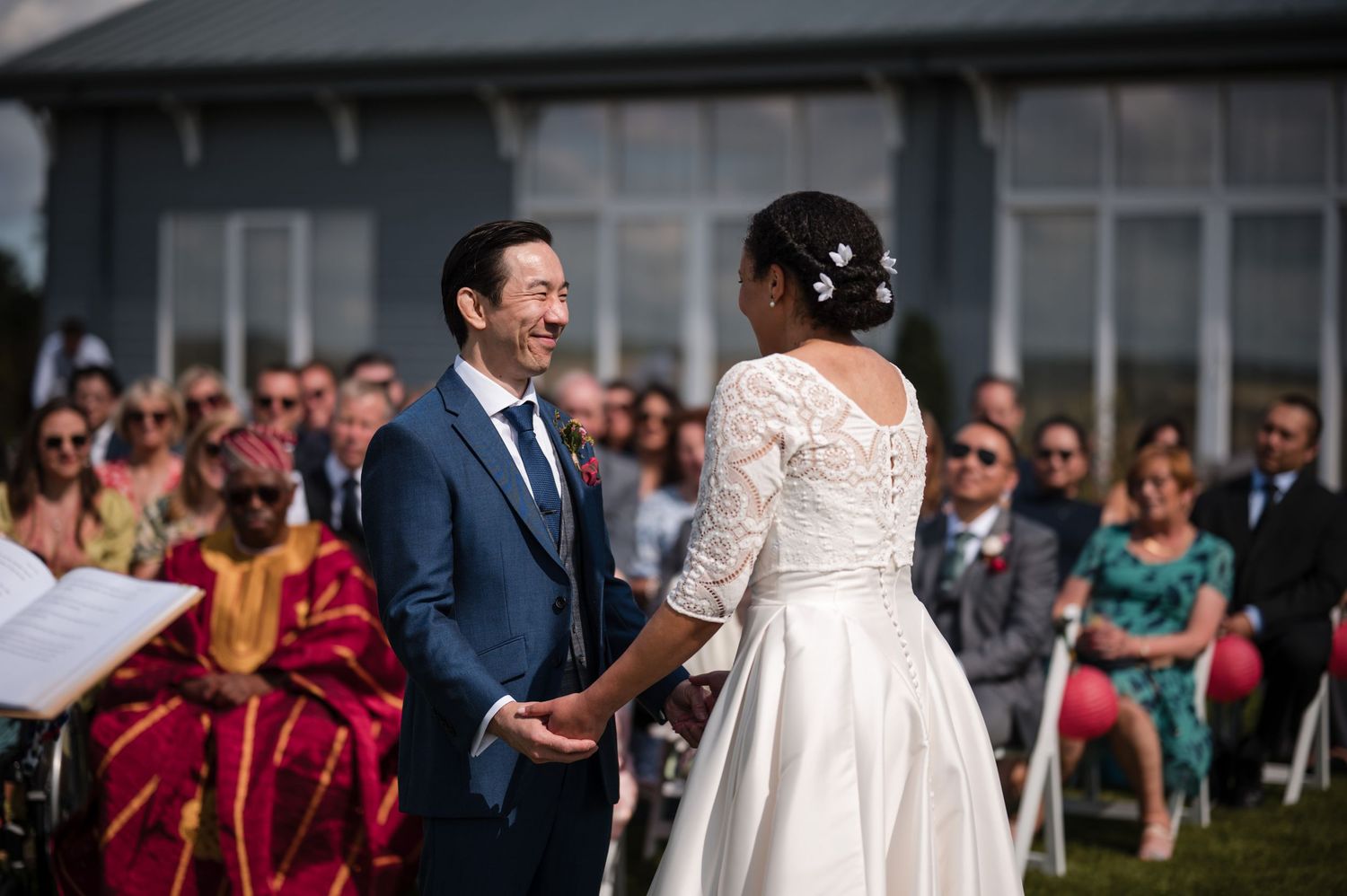 Wedding celebration with guests in formal attire gathered outdoors.