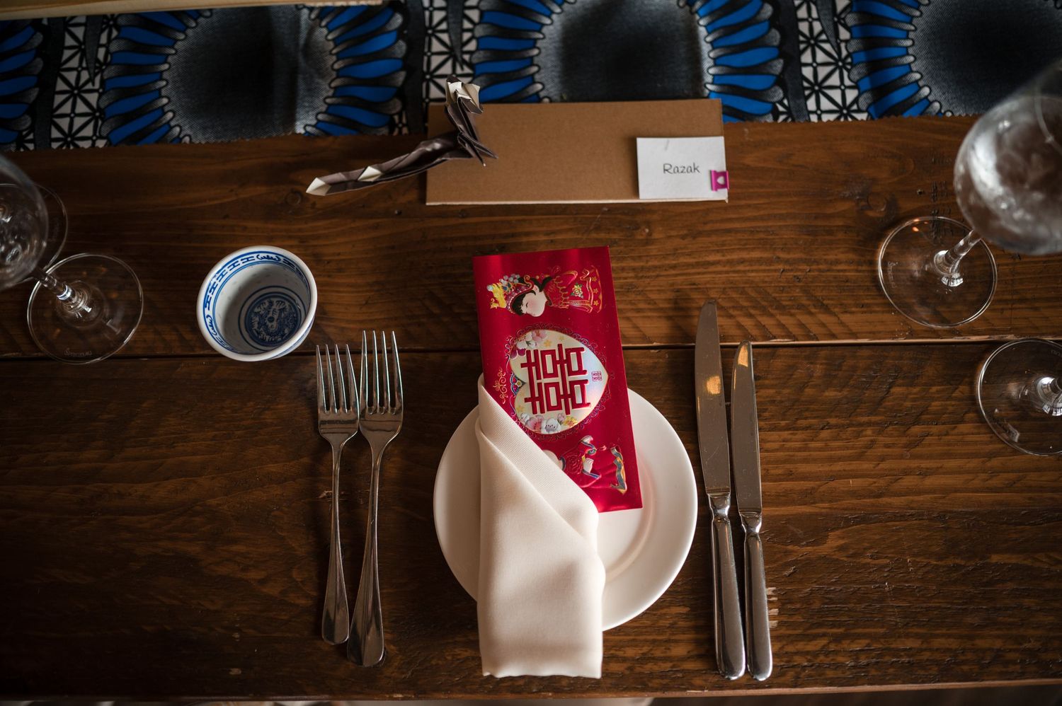 Rustic wedding table settings with red accents and wooden elements.