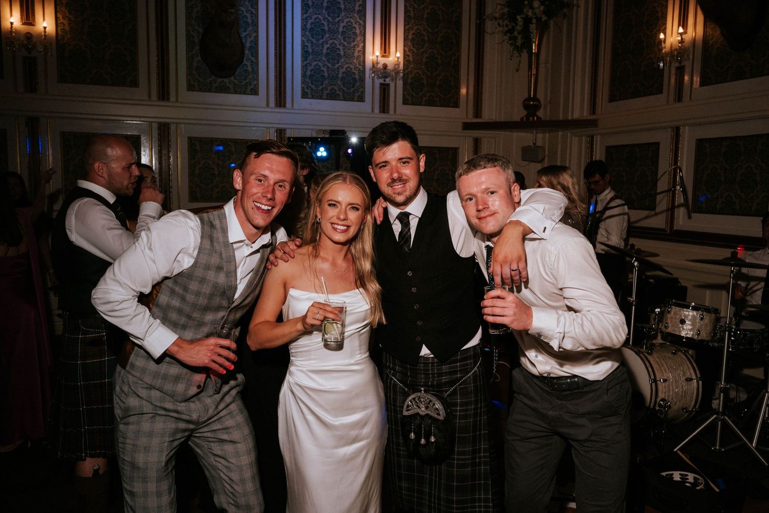 Wedding celebration with guests in formal attire enjoying festivities in an elegant venue.