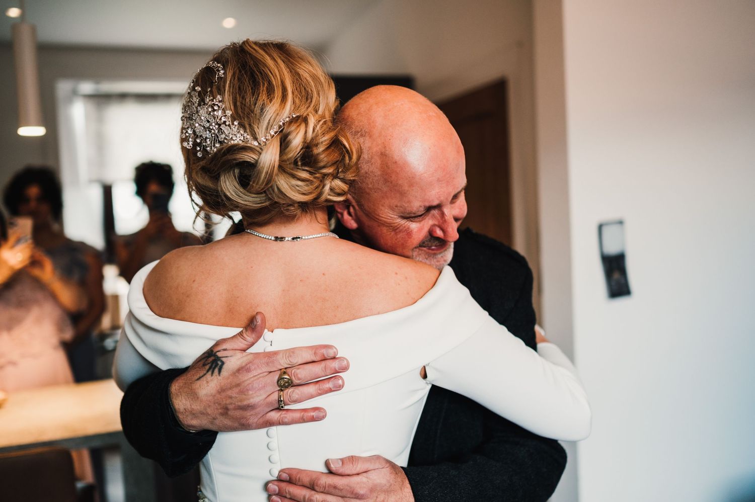 Tender embrace between bride and father during an emotional wedding day moment.