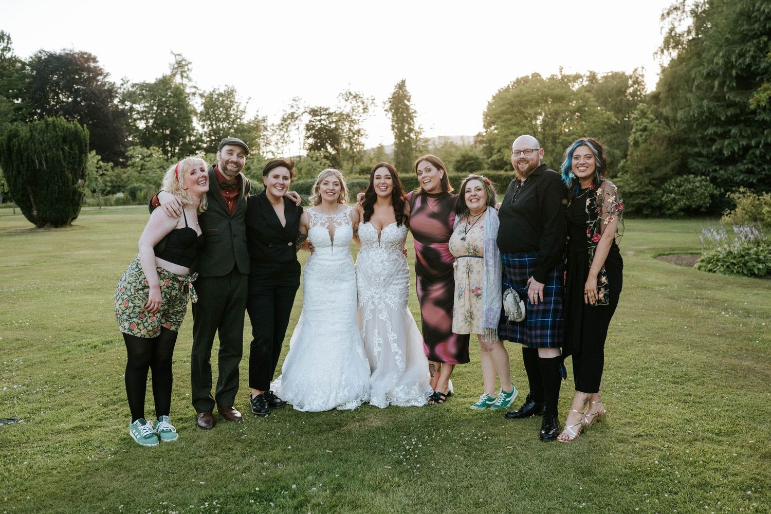 Aberdeen Wedding Photography. Wedding party group photo taken outdoors on a sunny day with green lawn background.