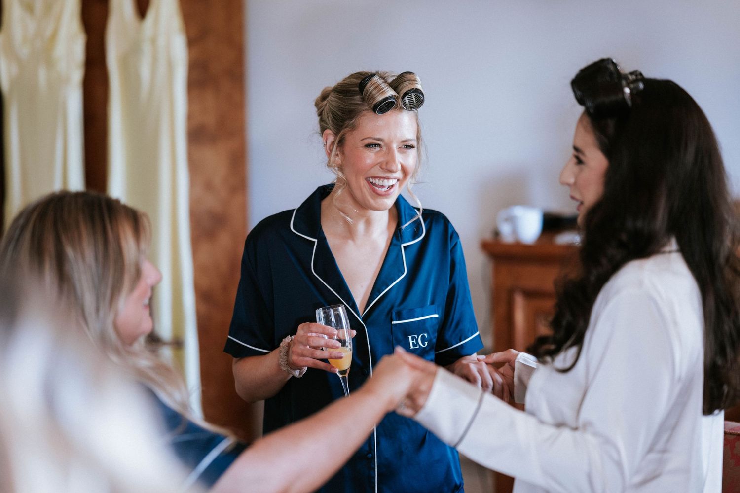 A group getting ready in the morning wearing matching navy pajamas share laughs together.
