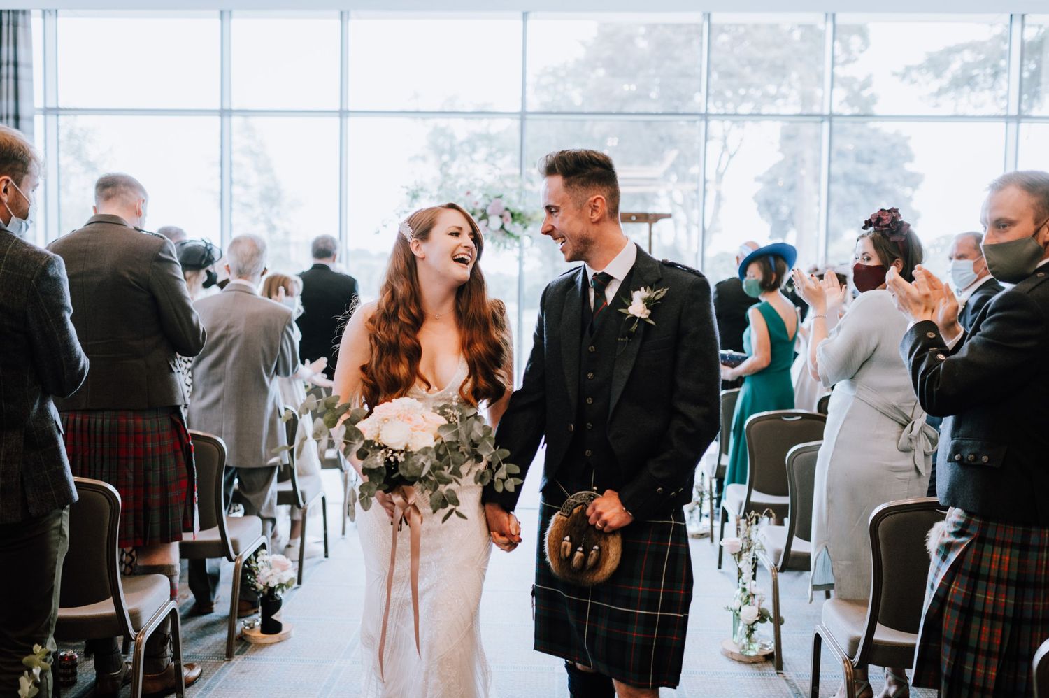 Scottish themed wedding ceremony with traditional kilts and flowing white gown.