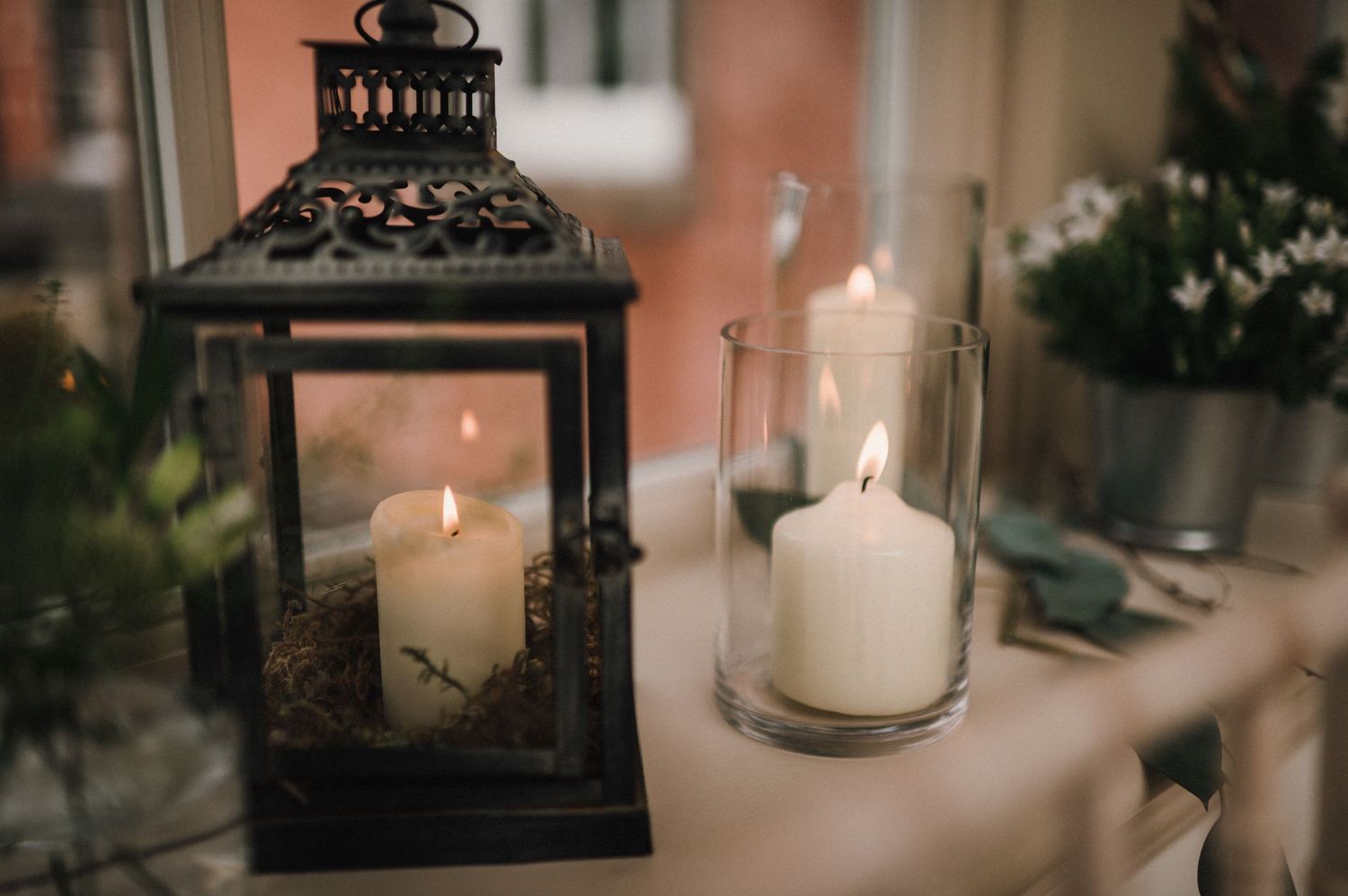 Decorative lantern and glass candle holders with lit candles creating romantic ambiance.