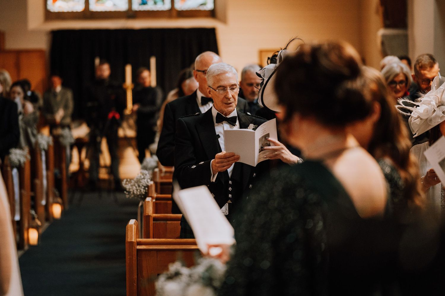 Wedding guests follow along with programs during a traditional church ceremony.
