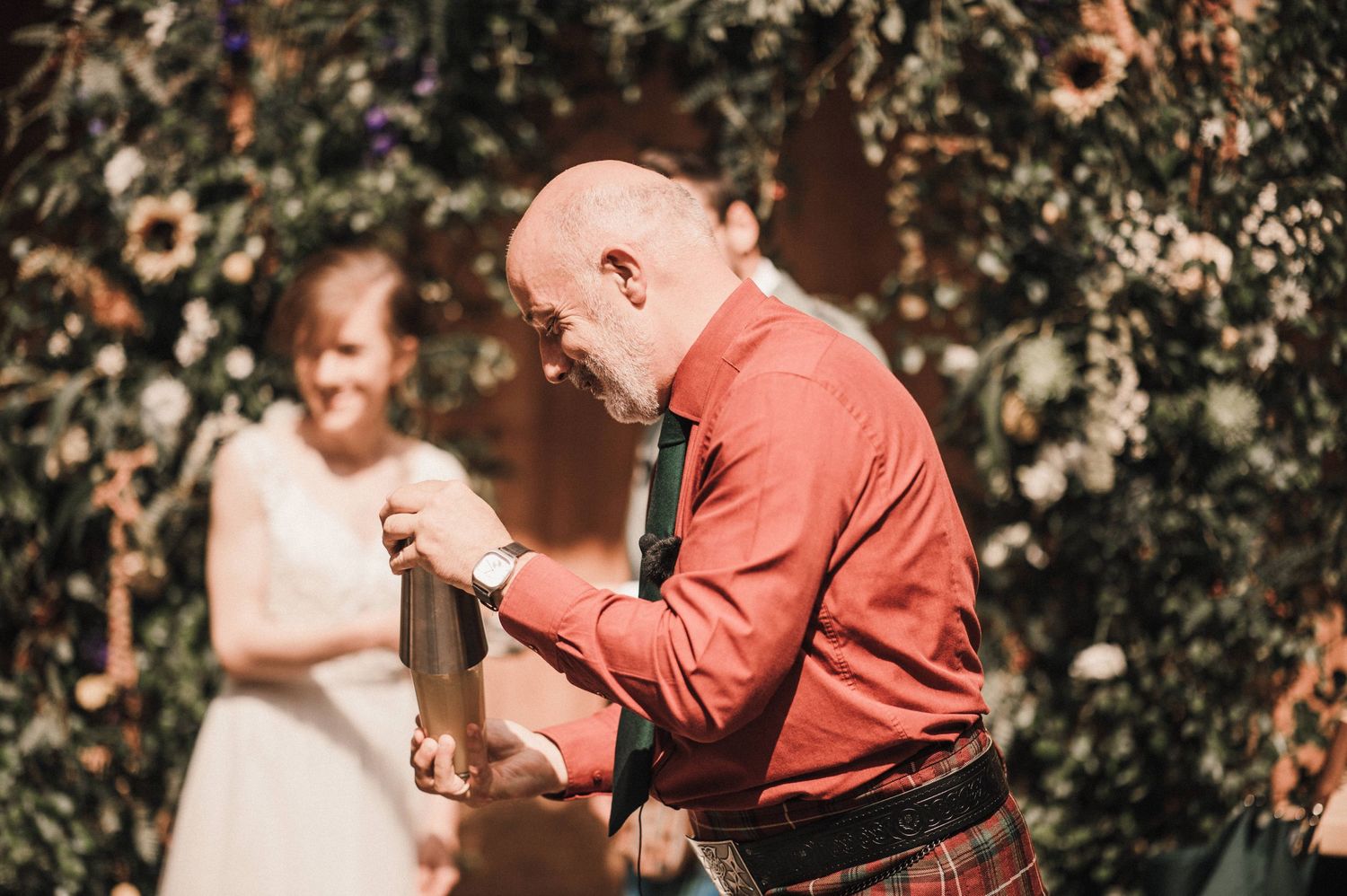 Wedding celebration moment captured outdoors with floral backdrop and festive atmosphere.