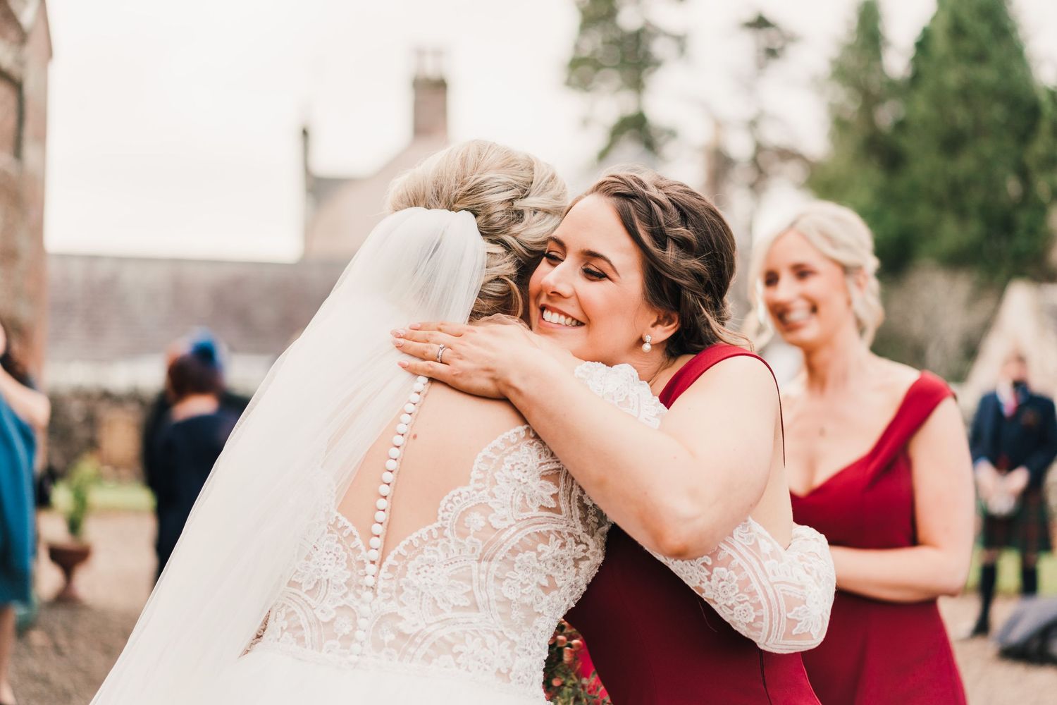 Emotional embrace outside brick church during winter wedding celebration.