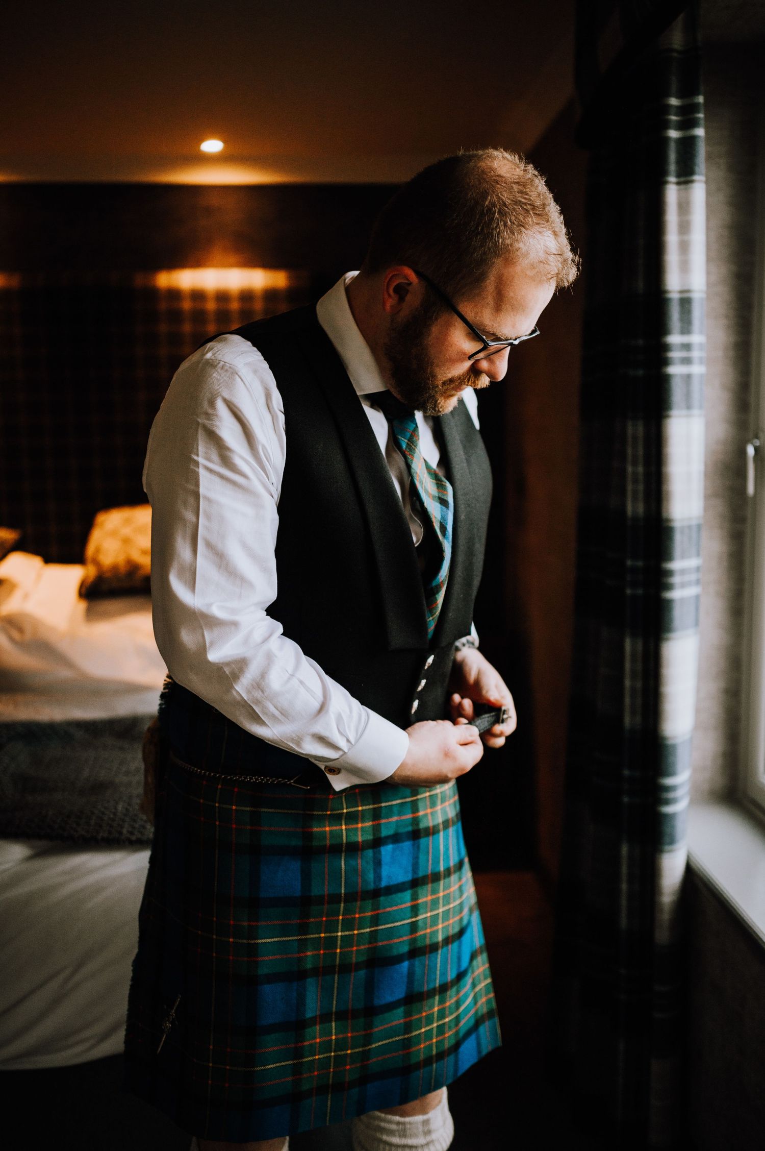 A detailed view of traditional Scottish formal wear with tartan kilt and waistcoat.
