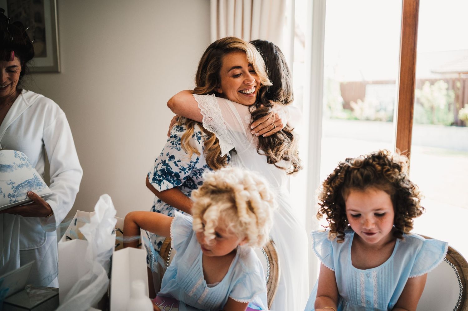 Candid moment of celebration and laughter with people in light blue dresses during a special occasion.