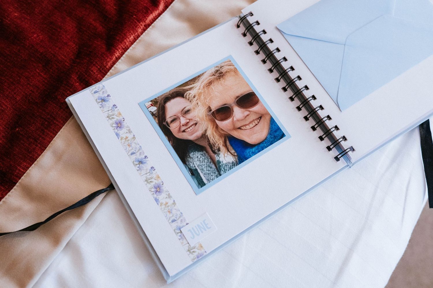Photo album page displaying a personal photograph against white and red fabric background.