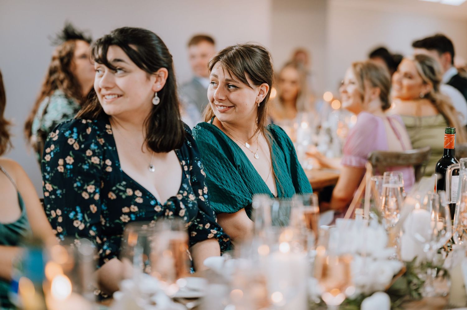 Guests enjoying themselves at an elegant wedding reception with wine glasses on the table.