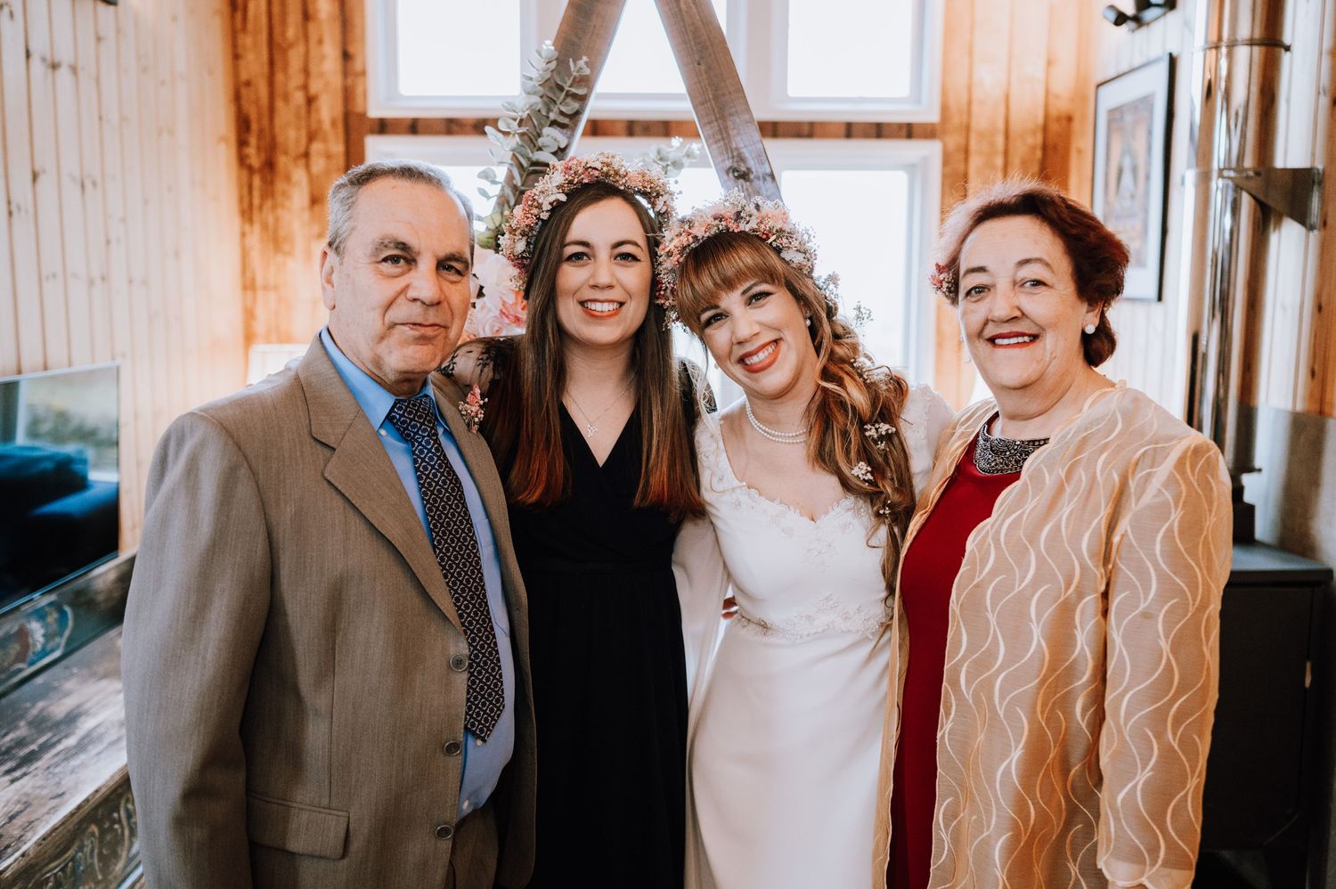 Group photo in rustic chapel with wood paneling and arched windows.