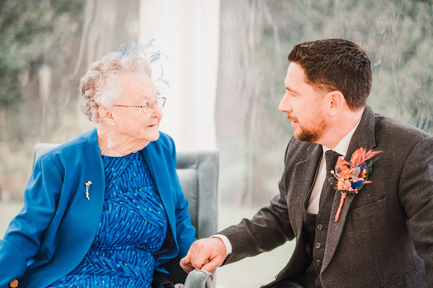 A warm moment shared between a person in blue dress and someone in formal attire.