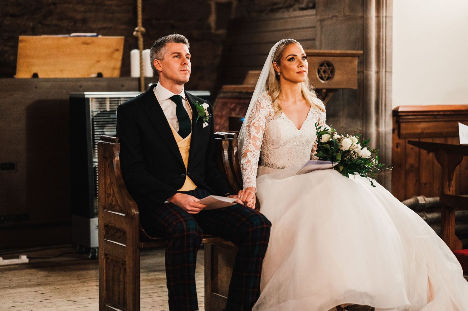 A wedding ceremony in a historic church with wooden pews and traditional decor.