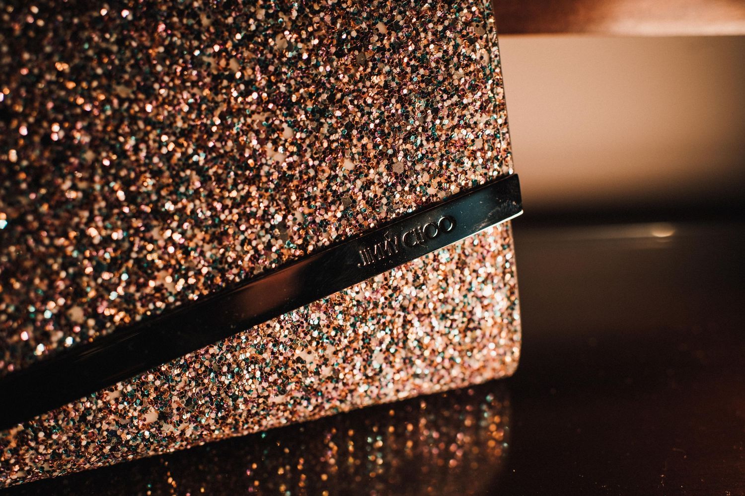 Close-up of a sparkly rose gold clutch handbag with metallic texture.