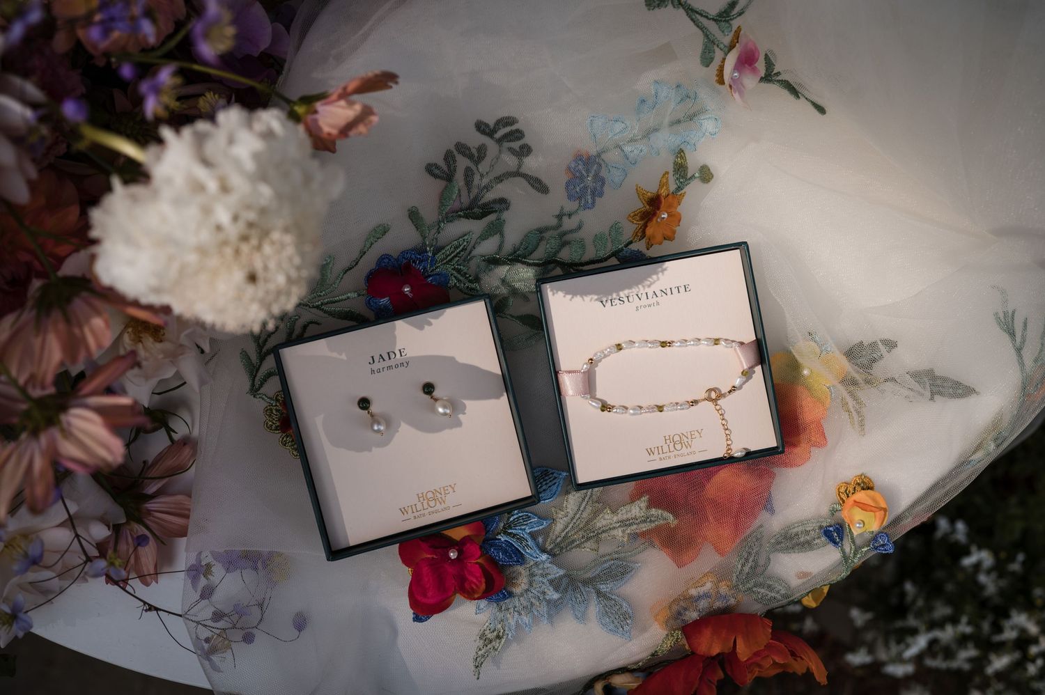 Wedding invitations with delicate floral designs laid out on a textured surface.