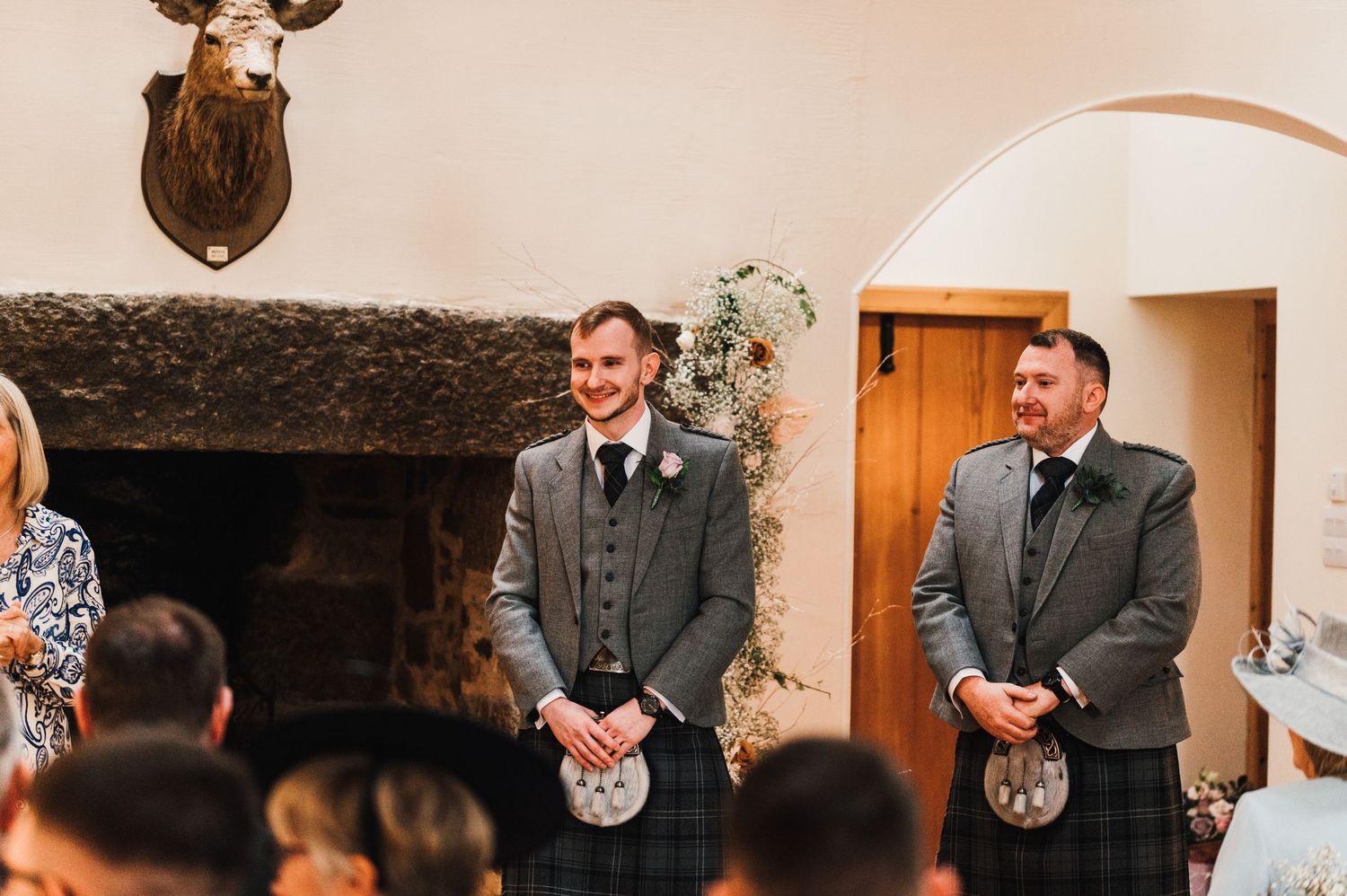Wedding celebration inside a rustic venue with exposed wooden beams.