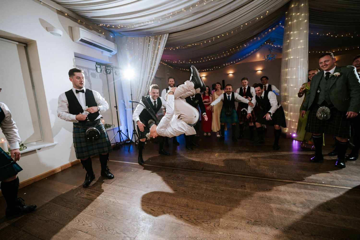 Aberdeen Wedding Photography. Wedding reception venue with white draped ceiling and elegant lighting setup.