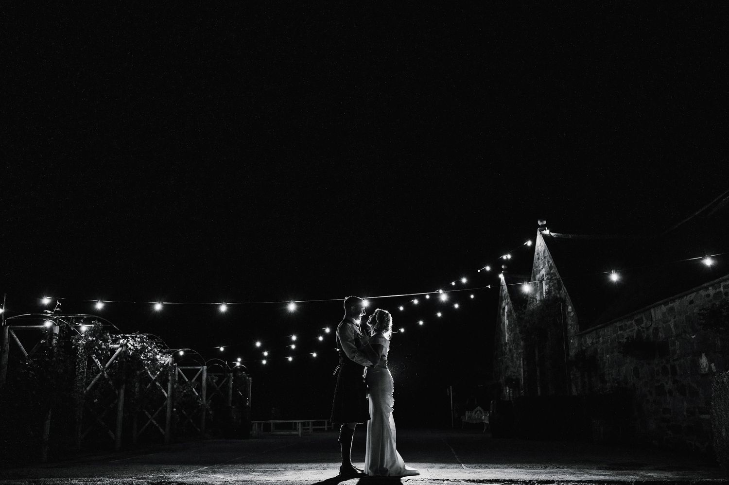 String lights illuminate an outdoor evening celebration creating a magical atmosphere.