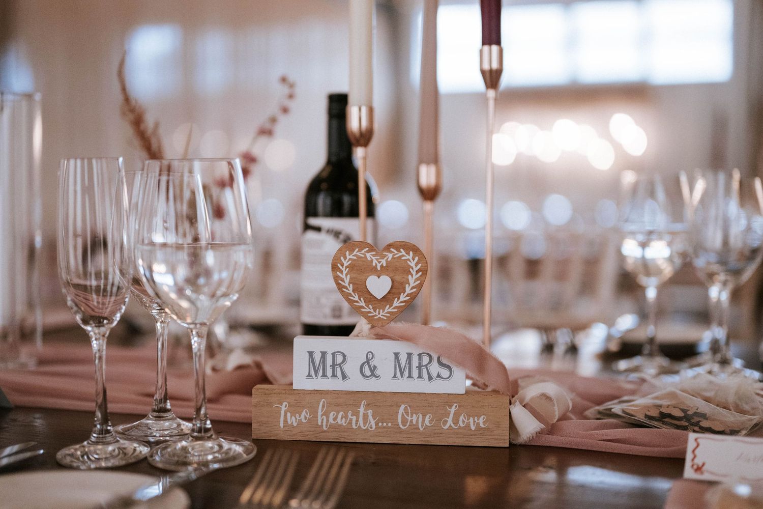 Wedding reception decor with 'Mr & Mrs' sign and wine glasses on display.