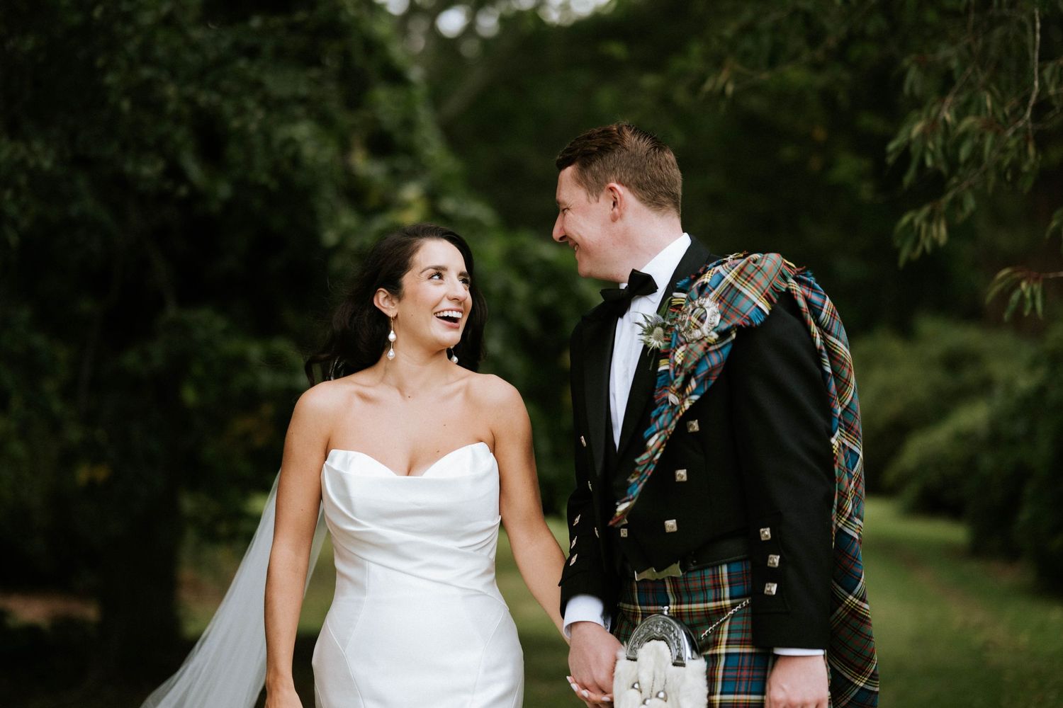 Candid wedding portraits showing joyful moments between newlyweds in a garden setting.