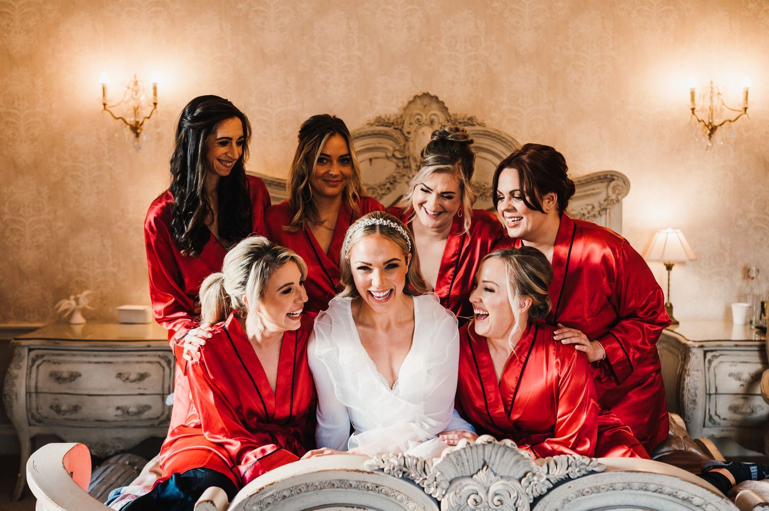 Group wearing matching red robes gathered together during wedding preparations.
