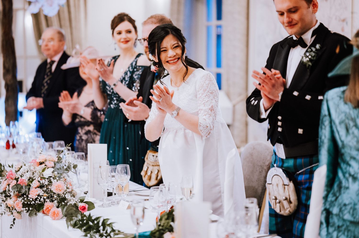 Wedding celebration with guests applauding during formal reception.