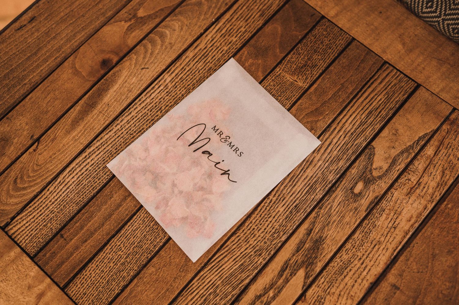 A handwritten menu card sits on a rustic wooden table surface.