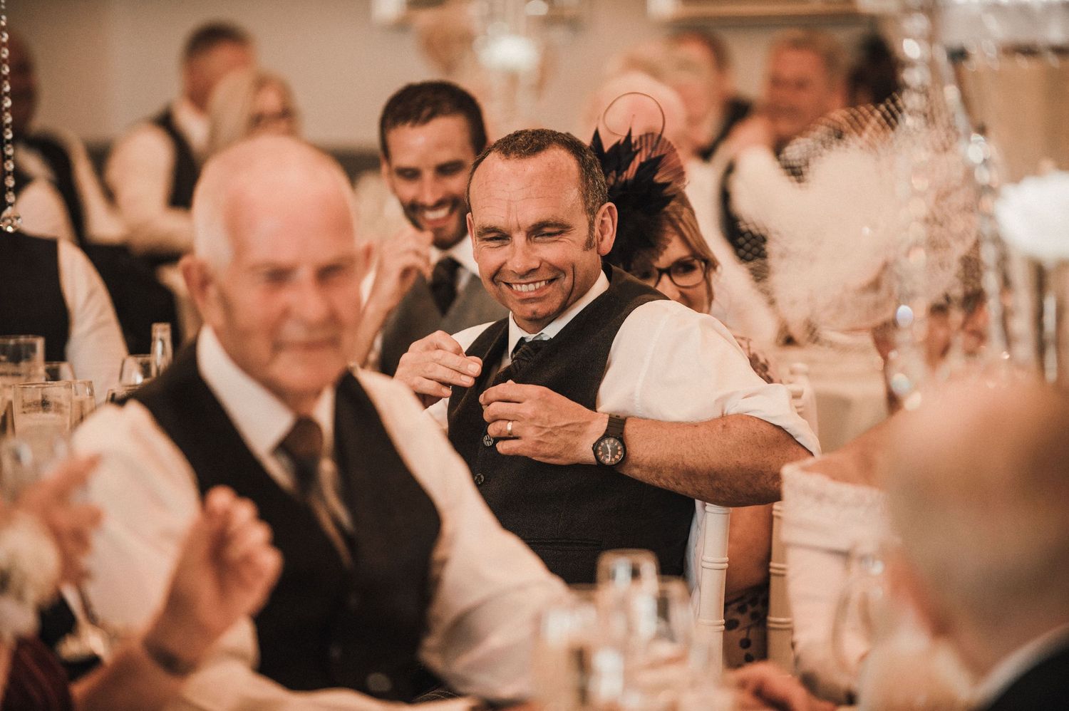 Candid moment of guests enjoying themselves at a formal wedding reception.
