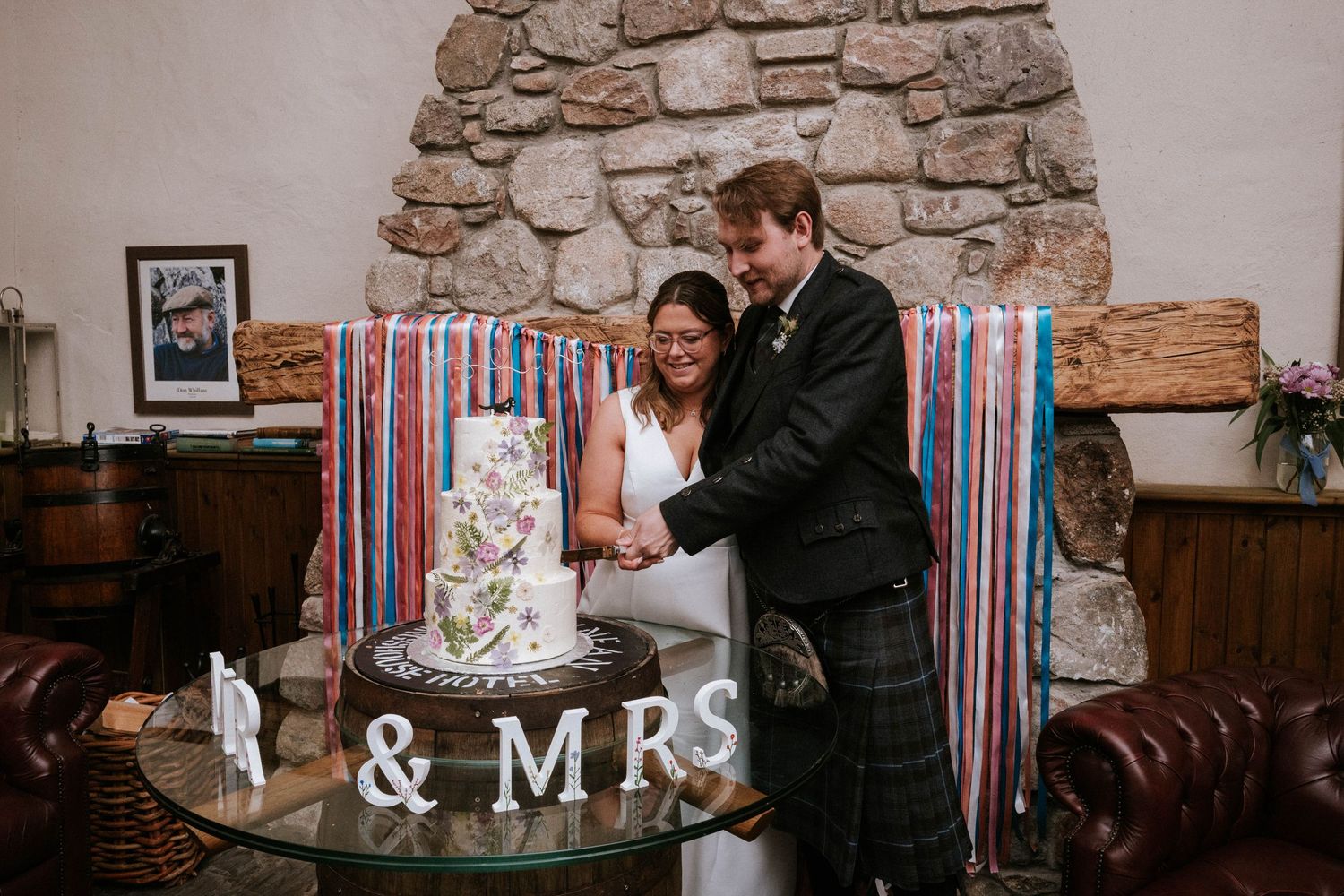 Stone wall decorated with wedding signage and decor in a rustic reception venue.