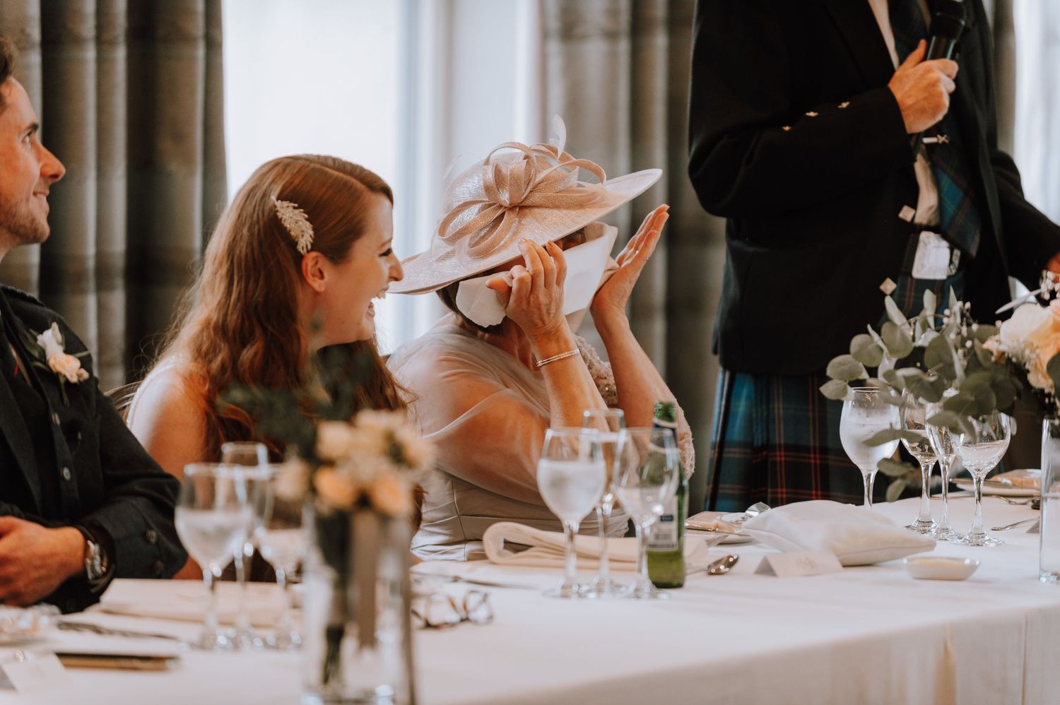 Wedding guests enjoying a formal dinner at an elegant reception table.