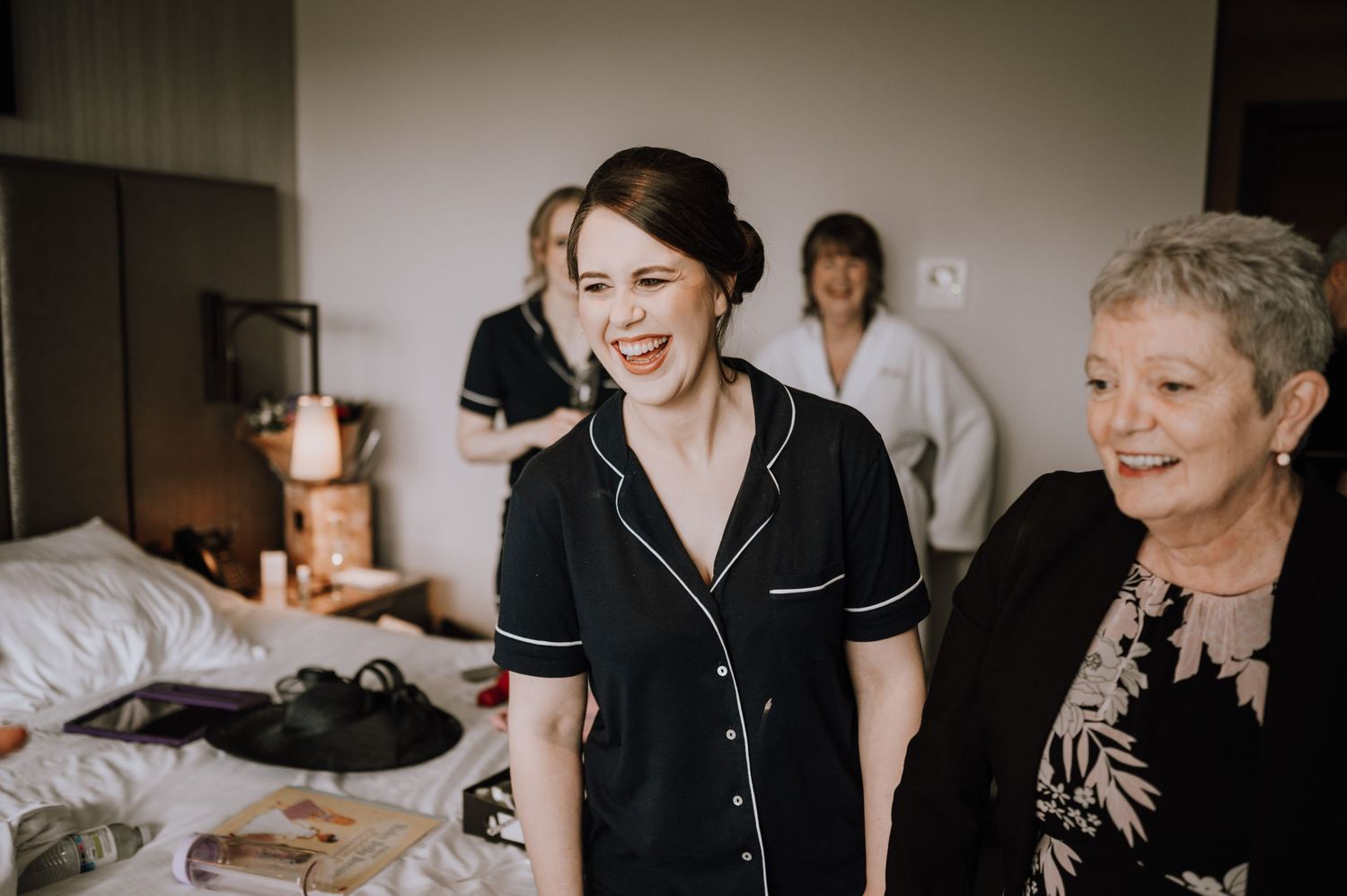Candid laughter shared during wedding morning preparations.