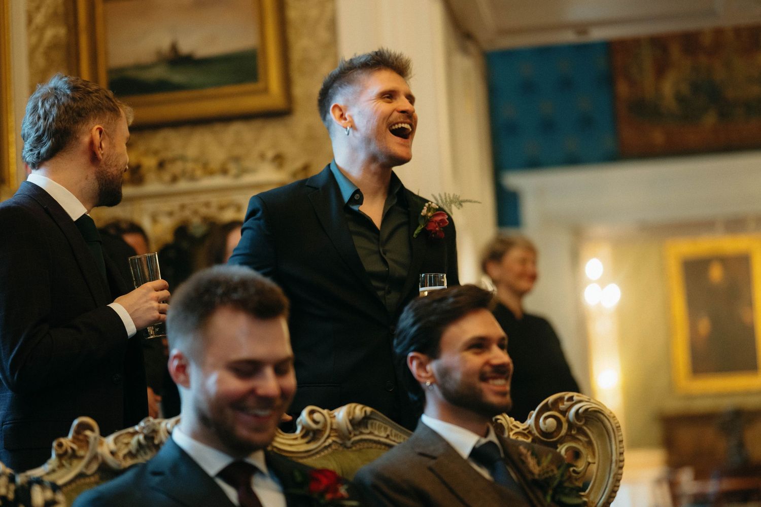 A joyful celebration in an elegant room with ornate gold decor and warm lighting.