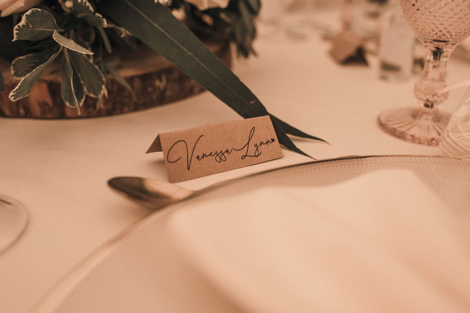 Close-up of wedding place card on elegant table setting.