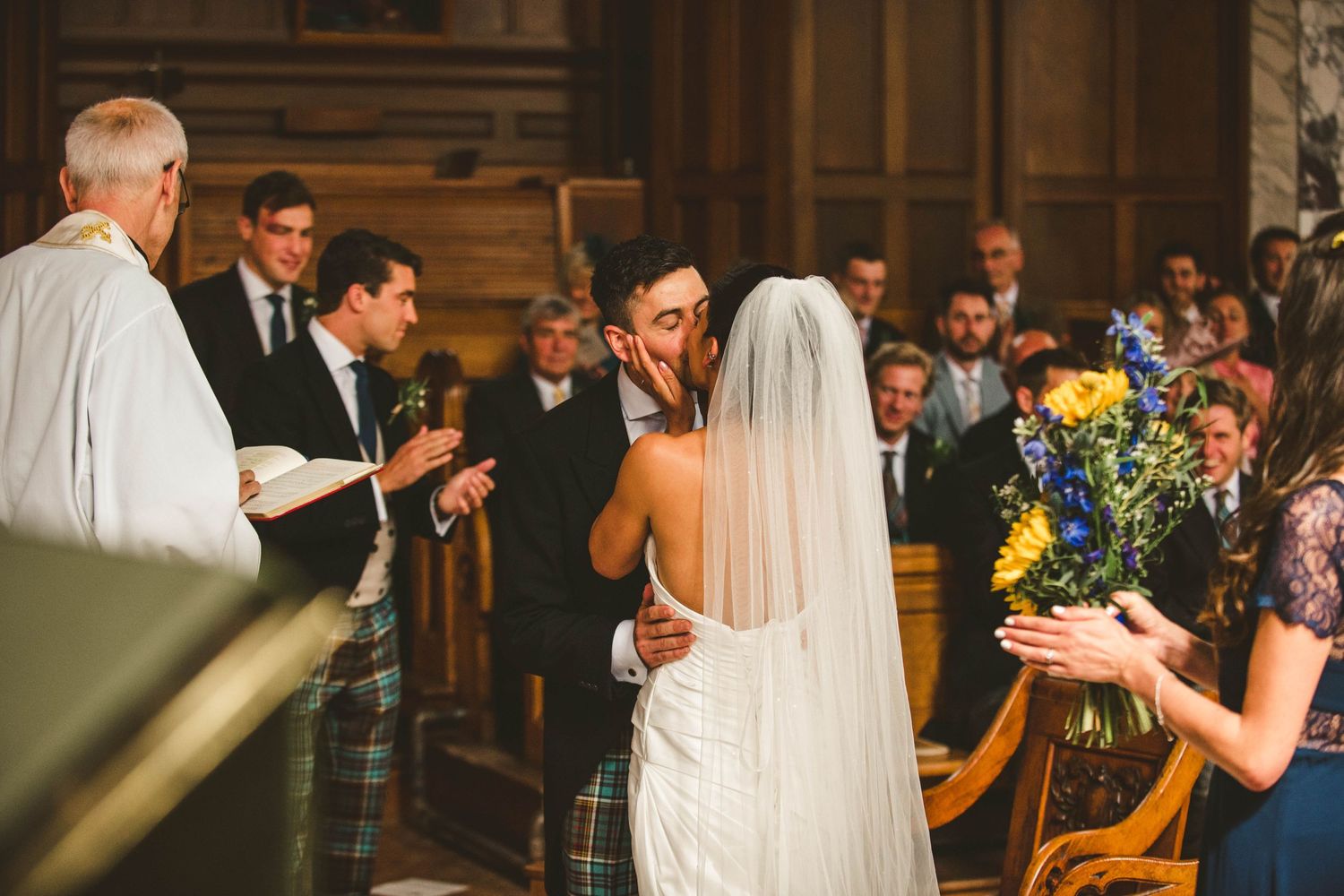 Clergy member conducts wedding ceremony while guests observe in traditional church setting.
