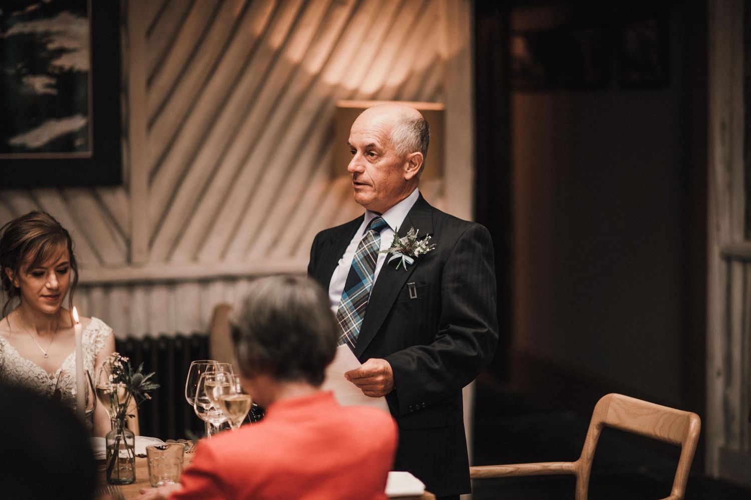 Formal gathering in an intimate venue with rustic wooden beam decor.