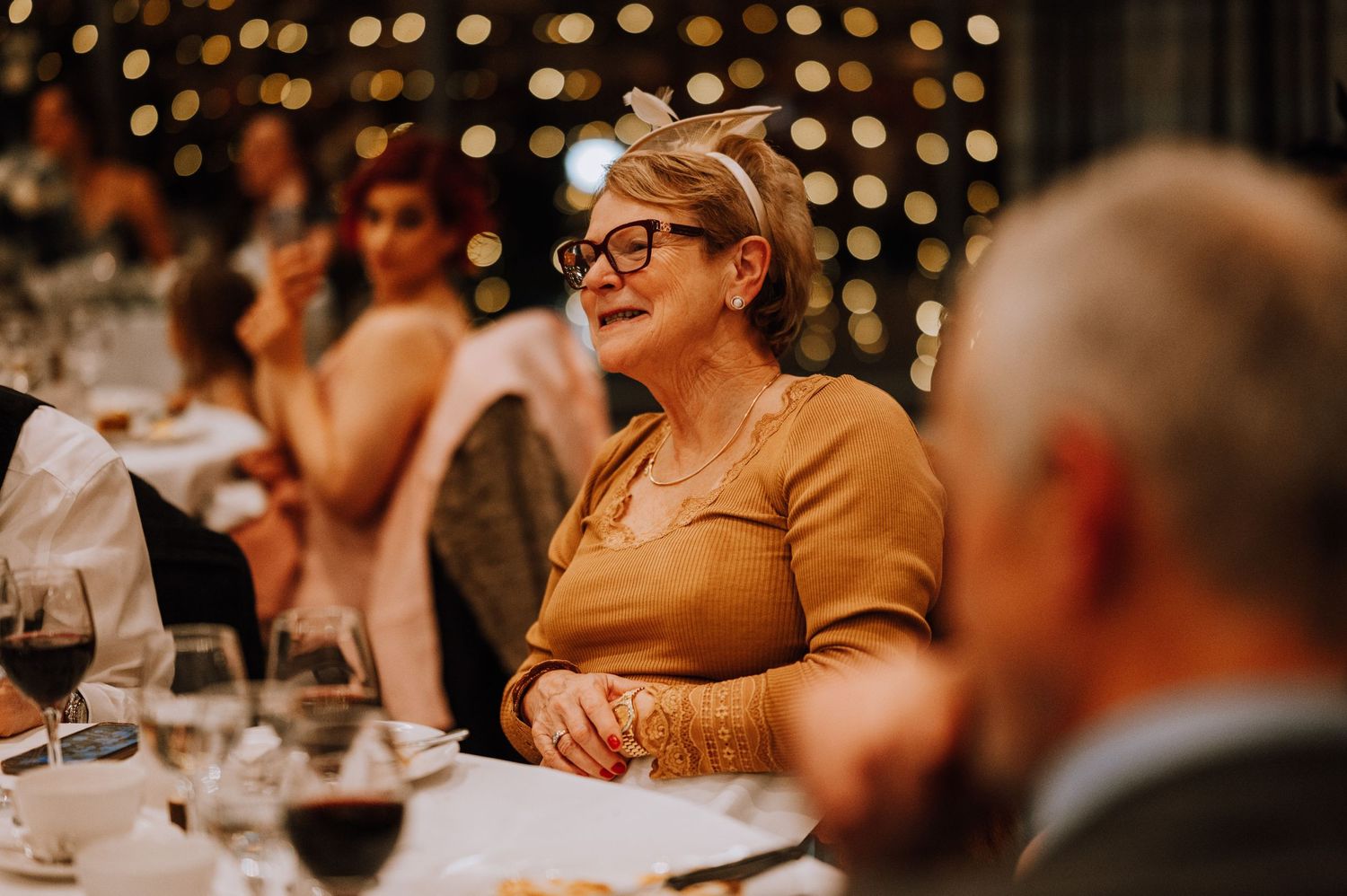 Guests enjoying an intimate moment during a wedding reception with twinkle lights in background.