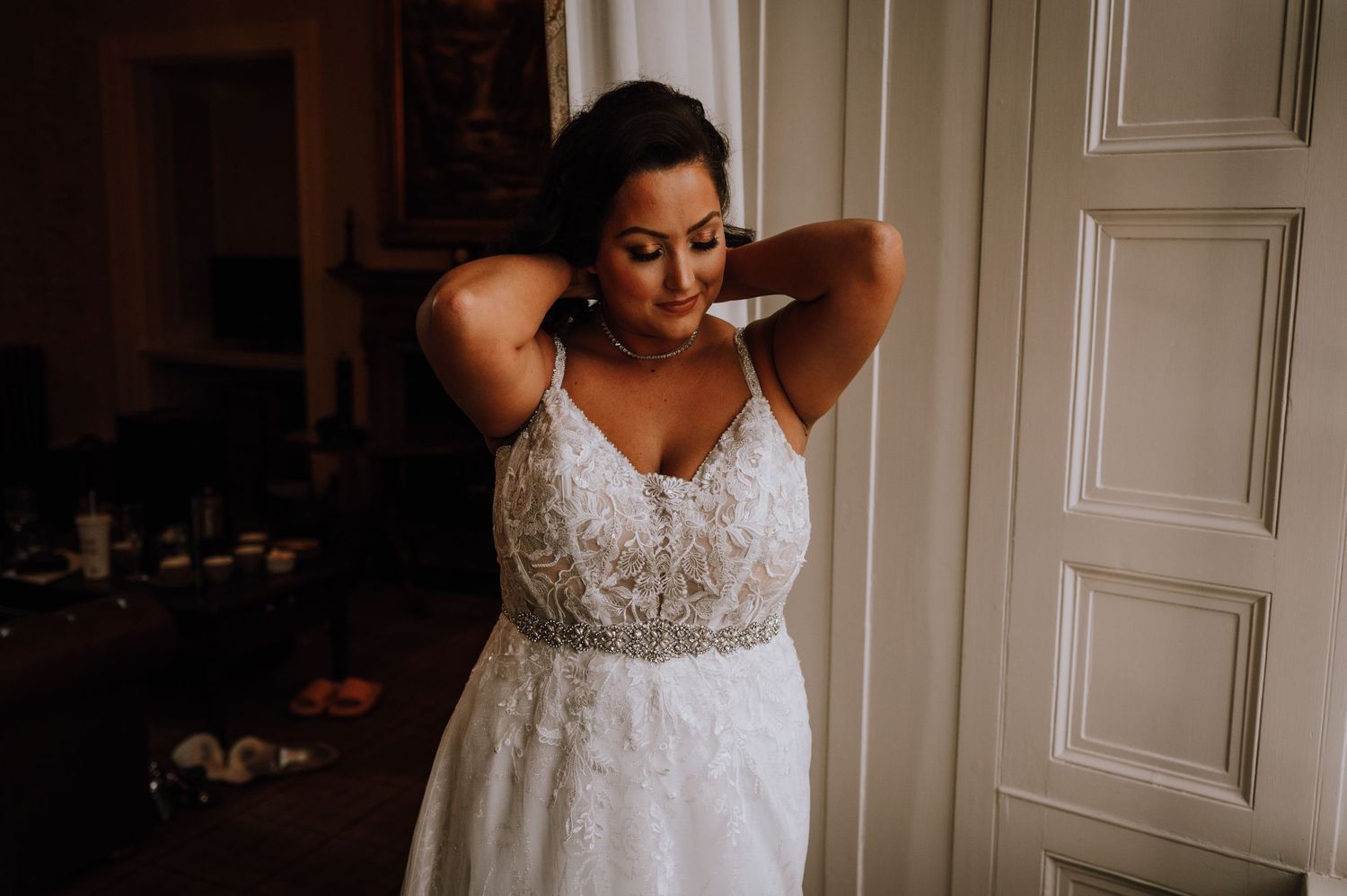 A beautiful lace wedding gown with intricate beading detail shown in warm natural light.