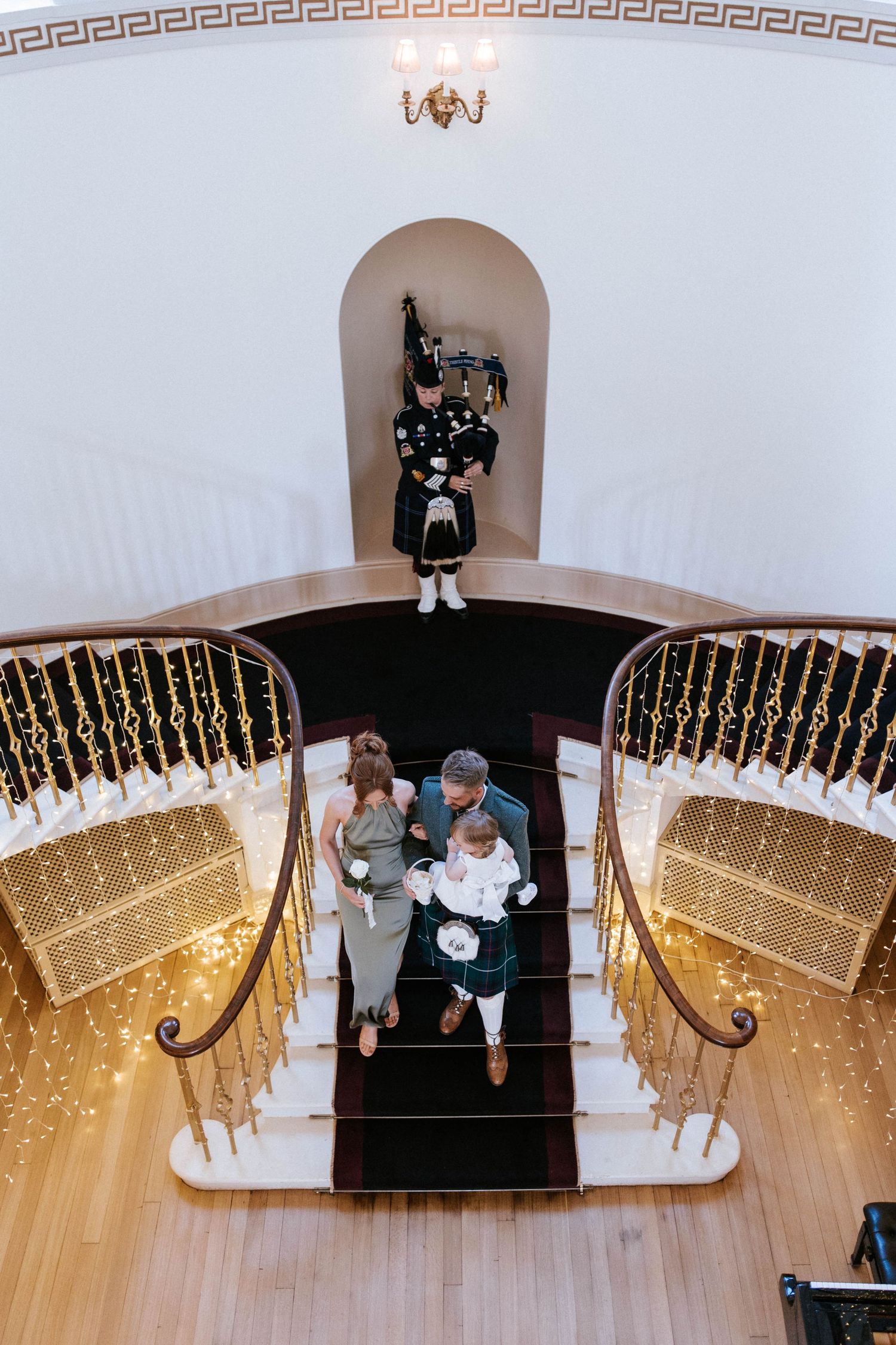 Wedding ceremony space decorated with hanging fairy lights and elegant Greek key pattern molding.