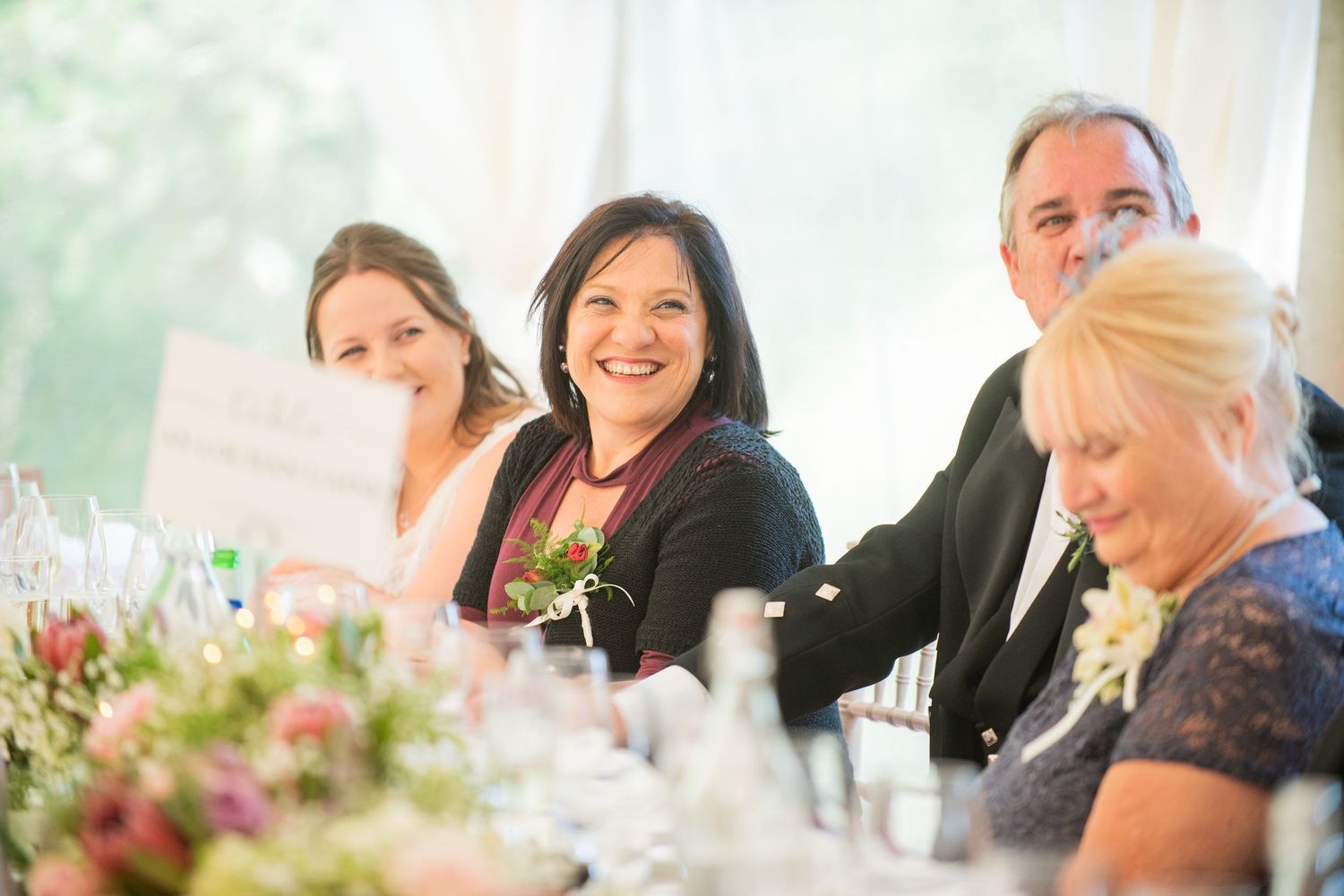Wedding reception guests enjoying conversation at decorated dining tables.
