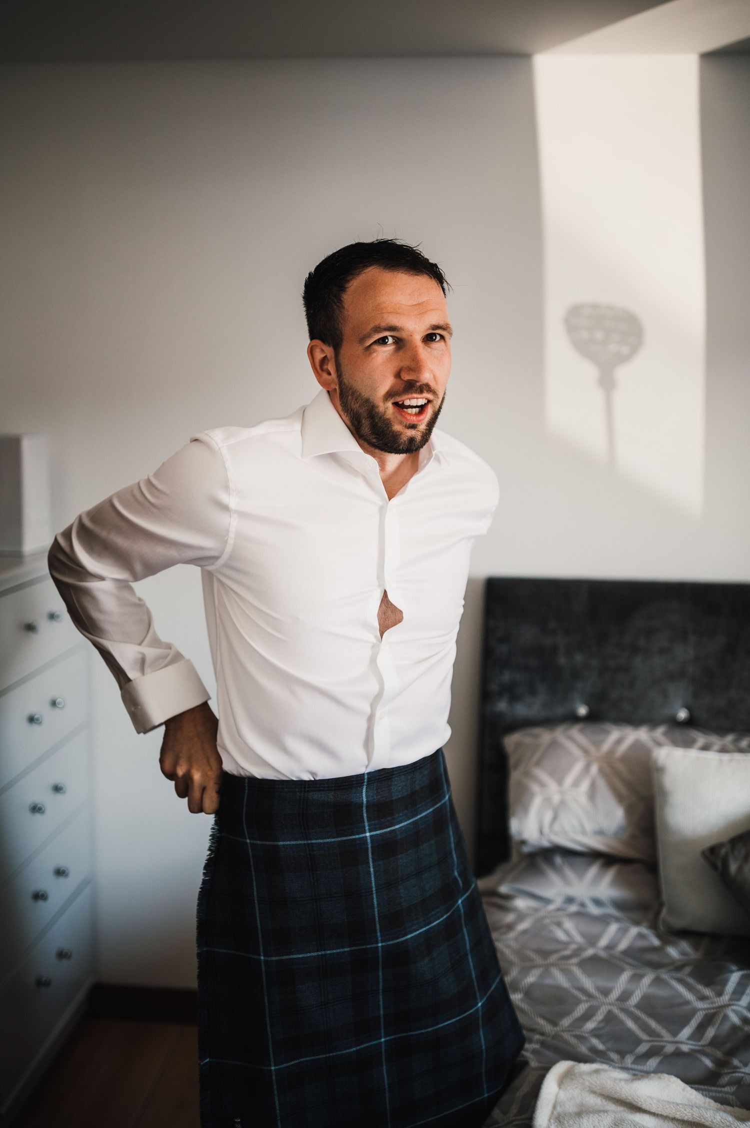 Someone wearing a traditional Scottish kilt and white dress shirt.