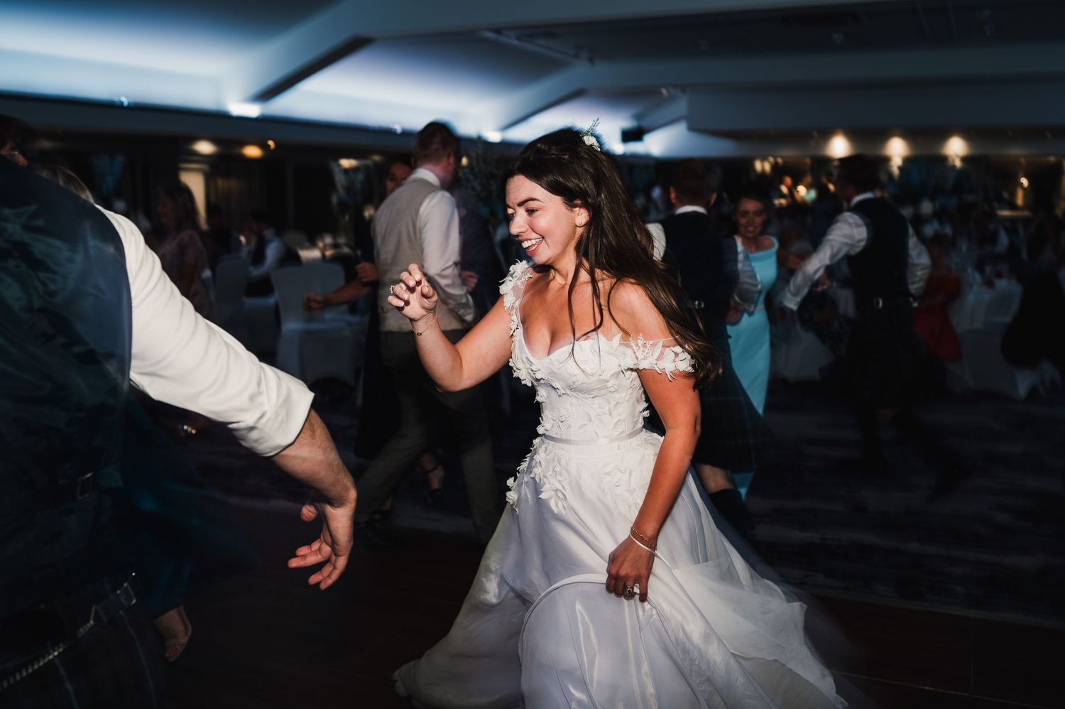 A bride in a white gown dances during her wedding reception celebration.