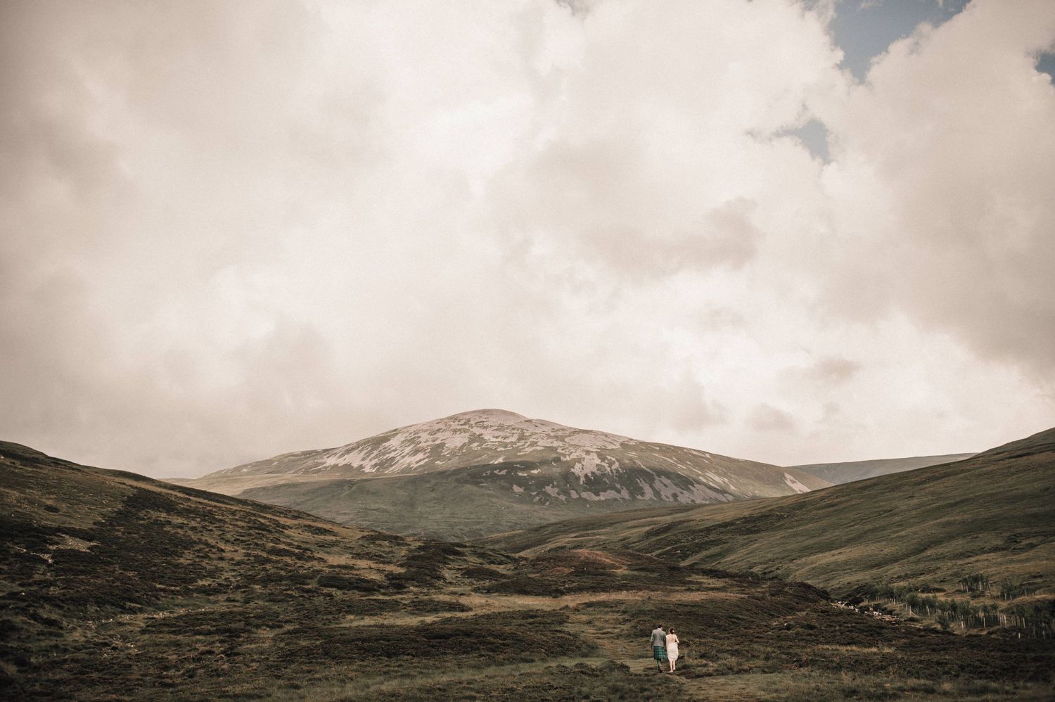 Dramatic mountainous landscape with hills and cloudy skies in Scotland.