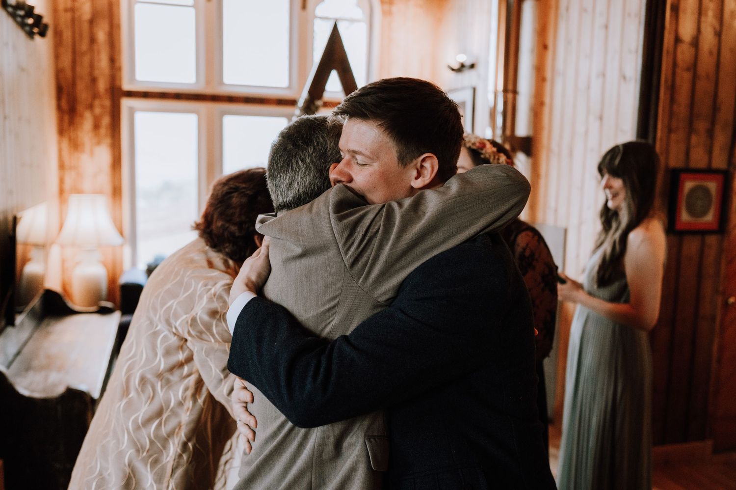 Tender moment of embracing during a wedding celebration in a rustic wooden venue.