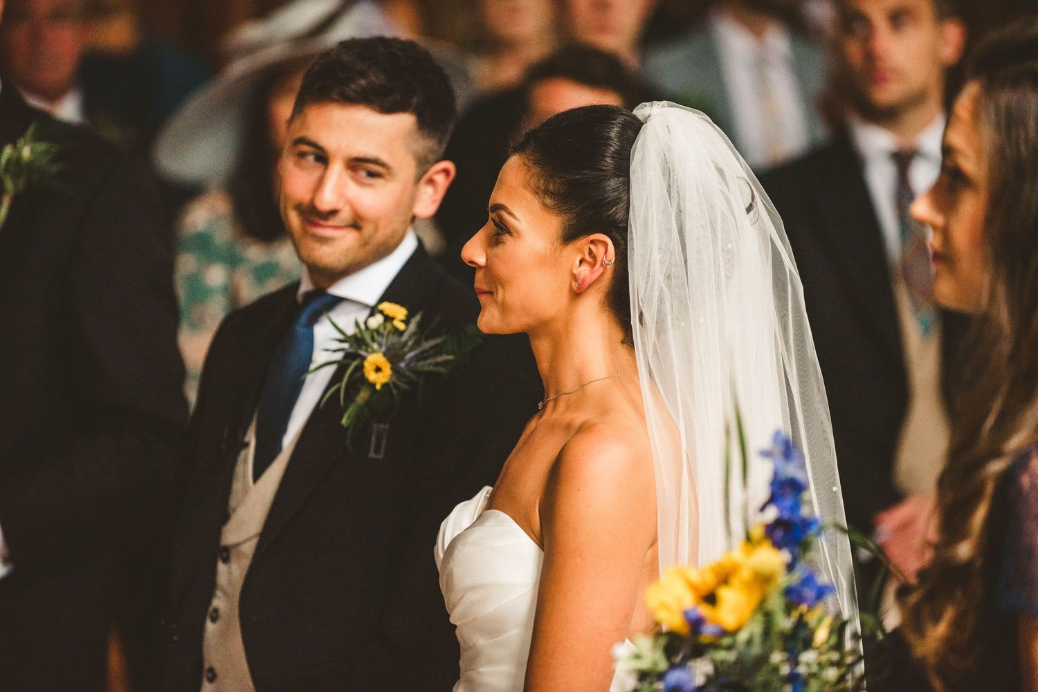 A couple shares a joyful moment during their wedding ceremony in a church setting.