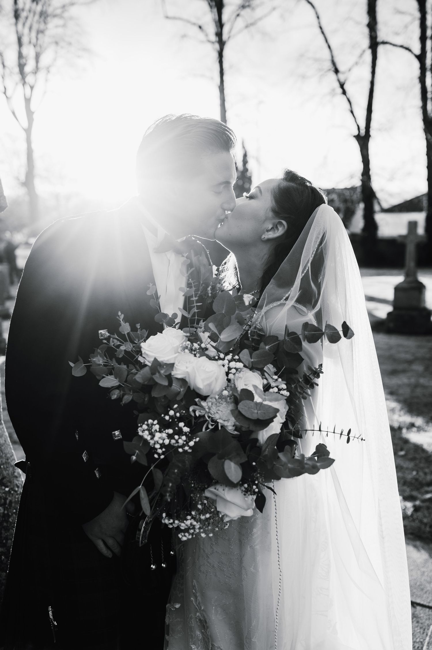 Aberdeen Wedding Photography. Romantic black and white portrait of newlyweds with sunlight and floral bouquet.
